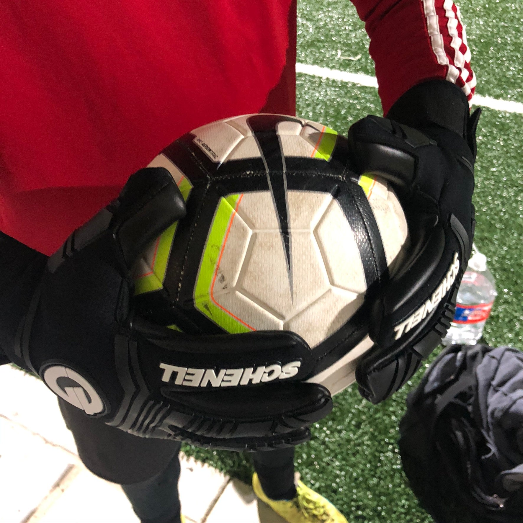 soccer goalie gloves holding a ball